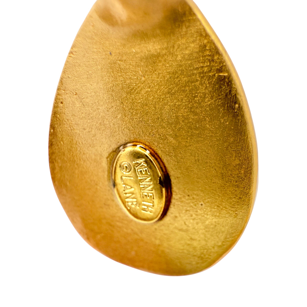Close-up of back of geometric gold earrings with sculpted texture