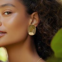 Model wearing bold Kenneth Jay Lane gold nugget clip-on earrings in sculptural form
