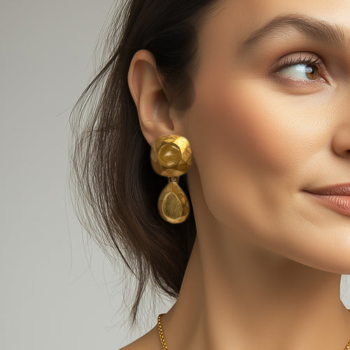 Model wearing Kenneth Jay Lane 22k gold plated cushion and pear drop earrings