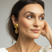 Model wearing Kenneth Jay Lane 22k gold plated cushion and pear drop earrings
