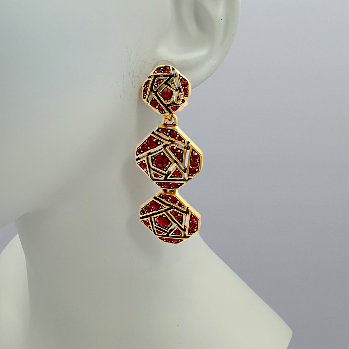 Side view of the earrings displayed on a mannequin, highlighting their length and intricate craftsmanship.