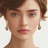 Model wearing Oscar de la Renta gold-plated glove earrings, styled with soft makeup for a sophisticated look.