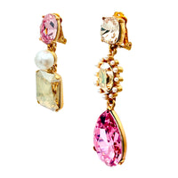 Close-up of Oscar de la Renta asymmetrical clip-on earrings featuring rose and light rose Austrian crystals with pearl accents, set in antique gold plating